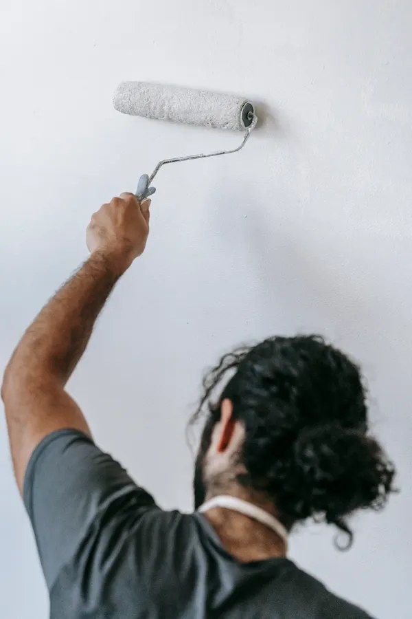 Painter rolling a fresh coat onto an interior wall